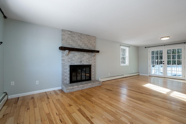 unfurnished living room featuring french doors, a baseboard radiator, a fireplace, and light hardwood / wood-style floors