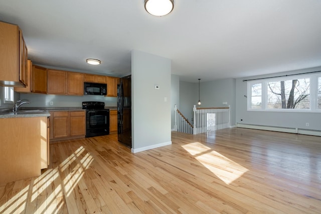 kitchen with decorative light fixtures, sink, baseboard heating, black appliances, and light wood-type flooring