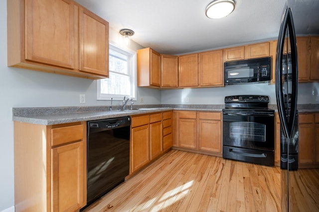 kitchen with sink, light wood-type flooring, and black appliances