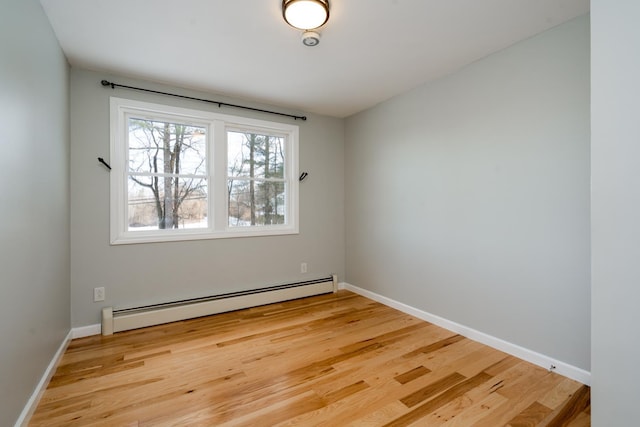 empty room featuring baseboard heating and light wood-type flooring