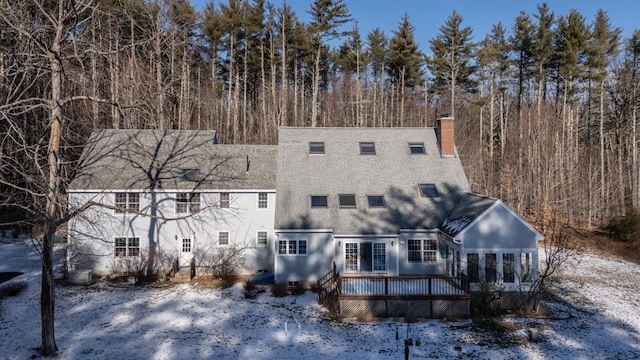 snow covered back of property featuring a deck