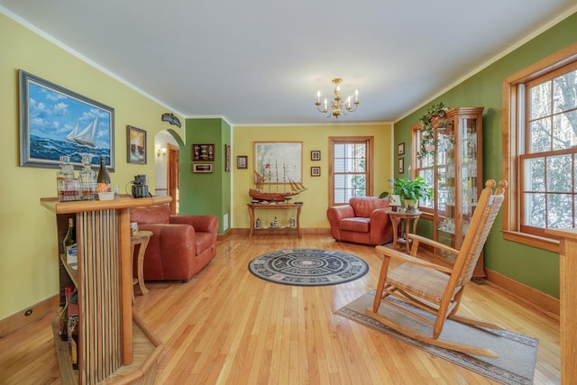 sitting room with a notable chandelier, hardwood / wood-style flooring, and ornamental molding