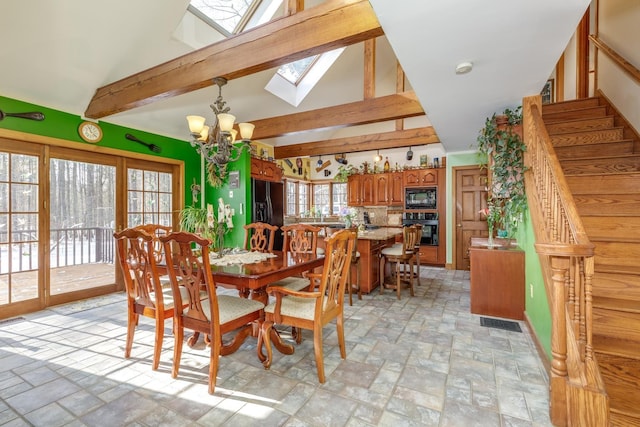 dining space with an inviting chandelier and lofted ceiling with skylight