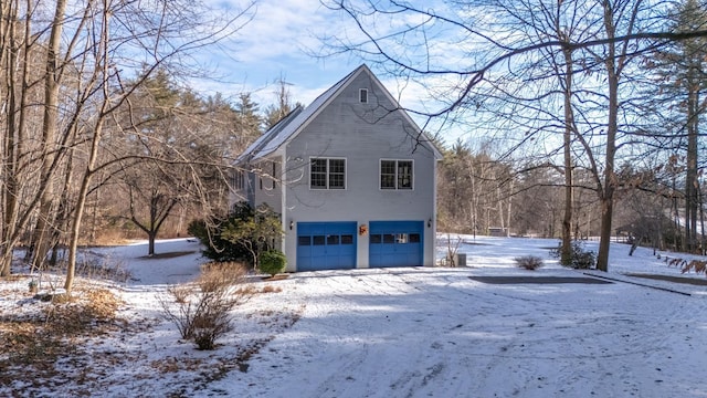 view of snow covered exterior featuring a garage