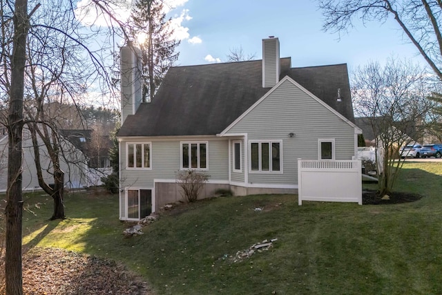 rear view of property featuring a lawn