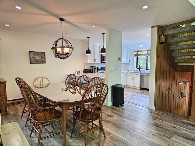 dining room with an inviting chandelier and light hardwood / wood-style flooring