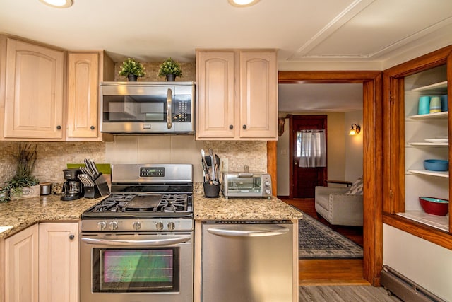 kitchen featuring tasteful backsplash, appliances with stainless steel finishes, light stone countertops, hardwood / wood-style floors, and a baseboard heating unit