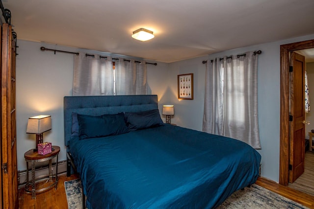 bedroom featuring hardwood / wood-style flooring and a baseboard radiator