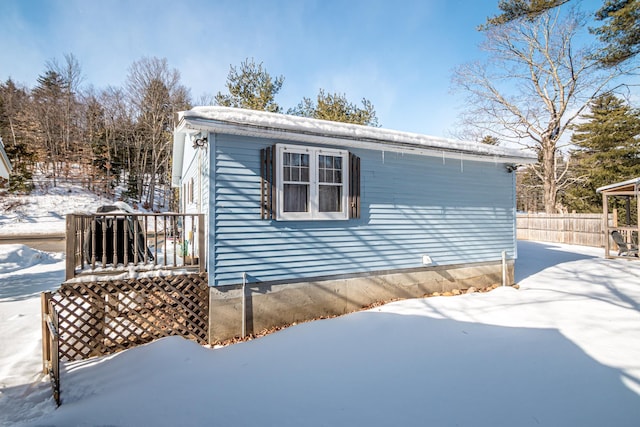 view of snowy exterior featuring a wooden deck