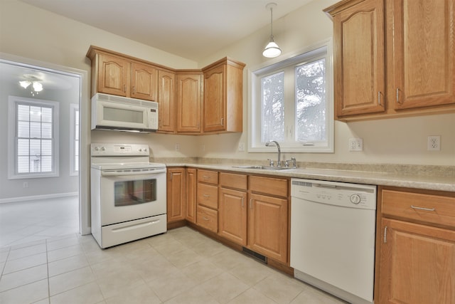 kitchen with pendant lighting, sink, white appliances, and a wealth of natural light