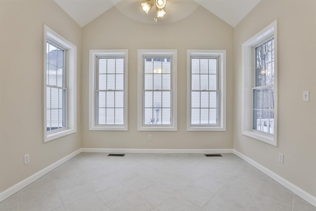 empty room with lofted ceiling, plenty of natural light, ceiling fan, and light tile patterned flooring