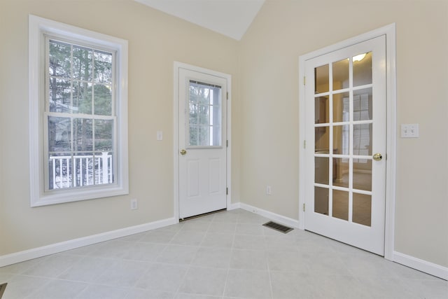 doorway to outside with lofted ceiling and light tile patterned floors