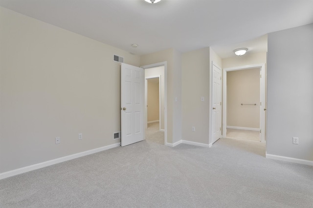 unfurnished bedroom featuring light carpet