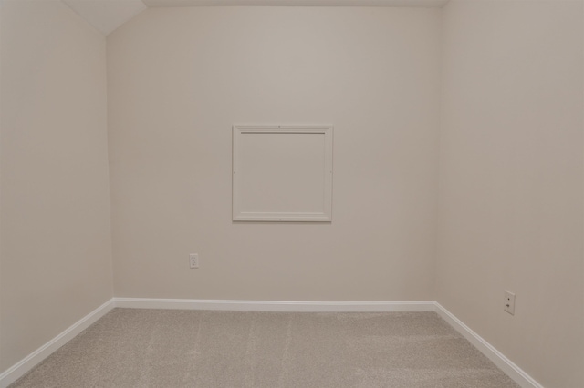 spare room featuring vaulted ceiling and carpet floors