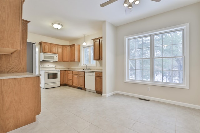 kitchen featuring ceiling fan, white appliances, decorative light fixtures, and sink