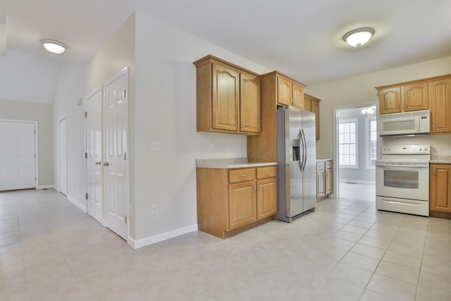 kitchen featuring light tile patterned floors and white appliances