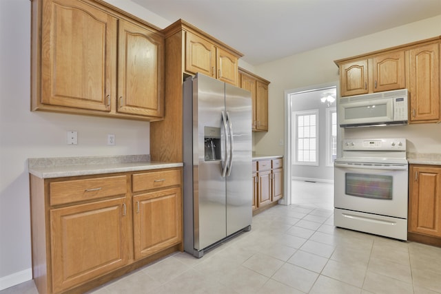 kitchen with white appliances and light tile patterned floors