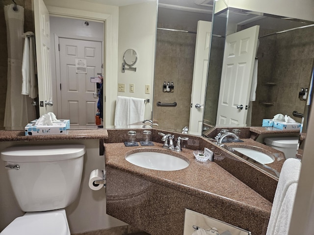 bathroom featuring vanity, tiled shower, and toilet