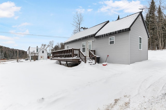 snow covered property with a wooden deck