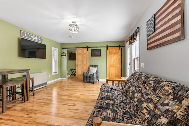 living room featuring a barn door and light wood-type flooring