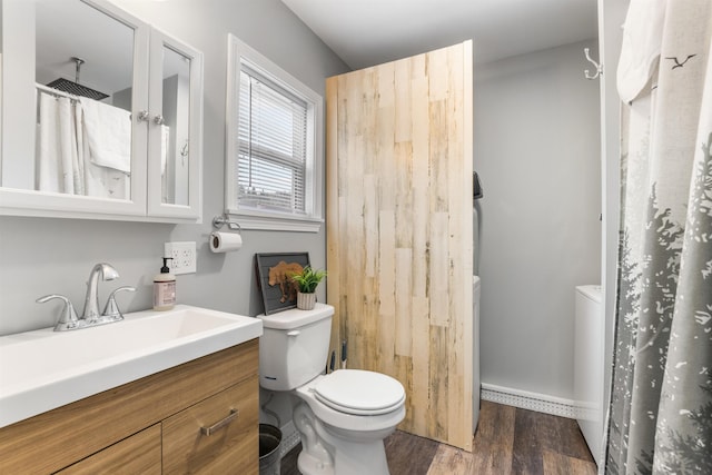 bathroom featuring hardwood / wood-style flooring, vanity, toilet, and curtained shower