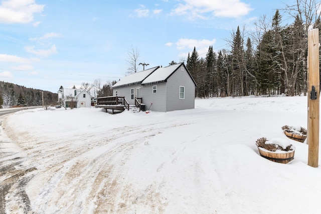 snow covered house with a wooden deck