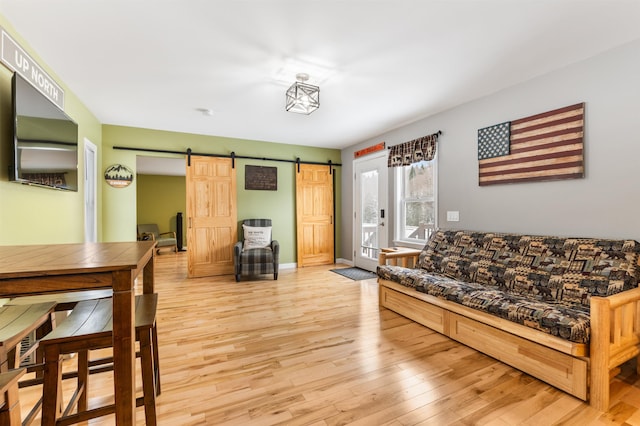 living room featuring a barn door and light hardwood / wood-style floors