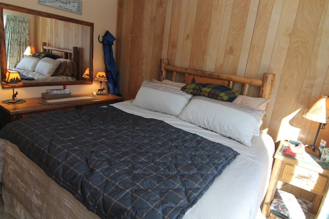 bedroom featuring wooden walls