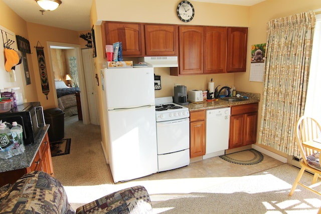 kitchen with white appliances, sink, and dark stone countertops