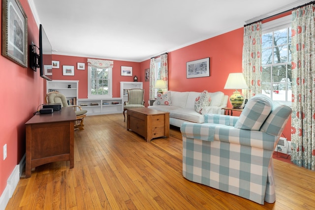 living room with ornamental molding and light hardwood / wood-style floors