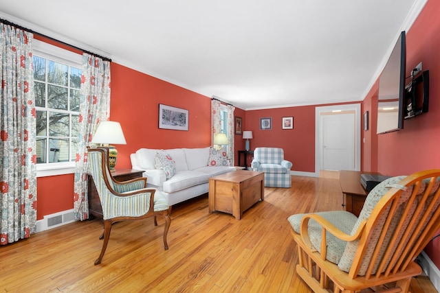 living room with ornamental molding and light wood-type flooring