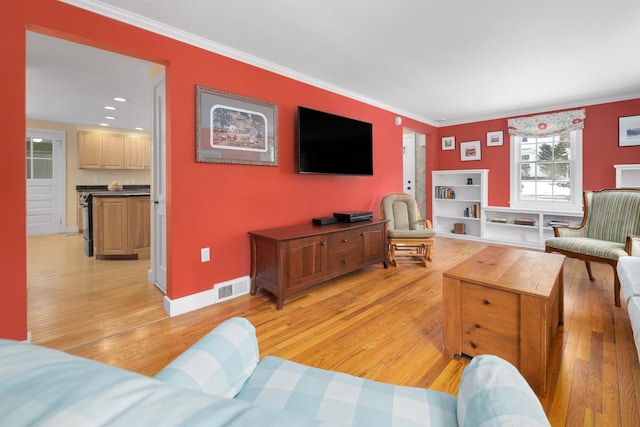 living room with ornamental molding and light hardwood / wood-style floors