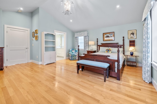 bedroom with an inviting chandelier, lofted ceiling, ensuite bathroom, and light wood-type flooring