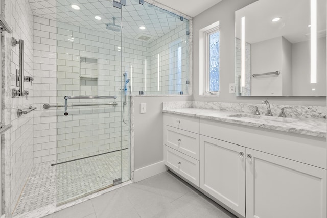 bathroom featuring tile patterned floors, vanity, and a shower with shower door