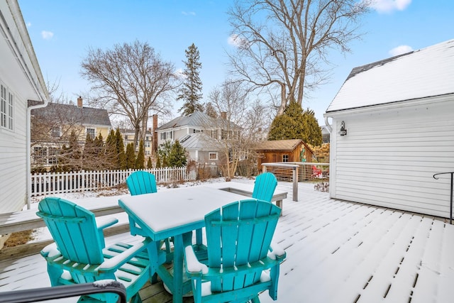 snow covered patio featuring an outdoor structure and a deck