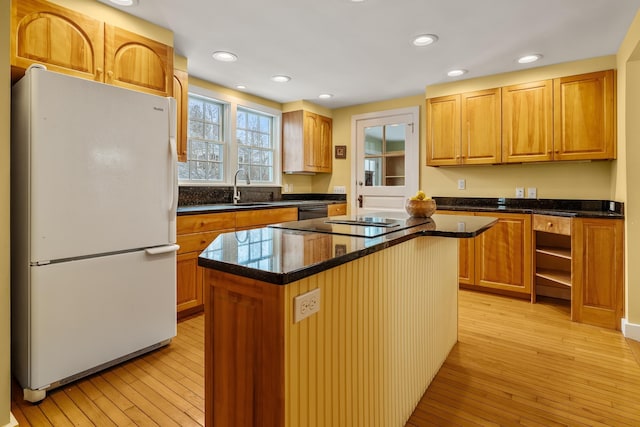 kitchen with sink, a center island, light hardwood / wood-style flooring, dishwasher, and white fridge