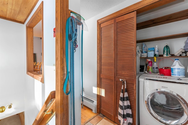 clothes washing area featuring washer / dryer and a baseboard heating unit