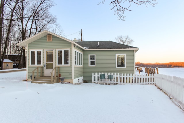 view of snow covered rear of property