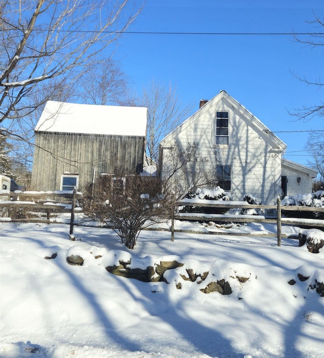 view of snow covered exterior with an outbuilding