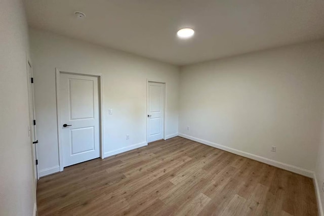 unfurnished bedroom featuring light wood finished floors and baseboards