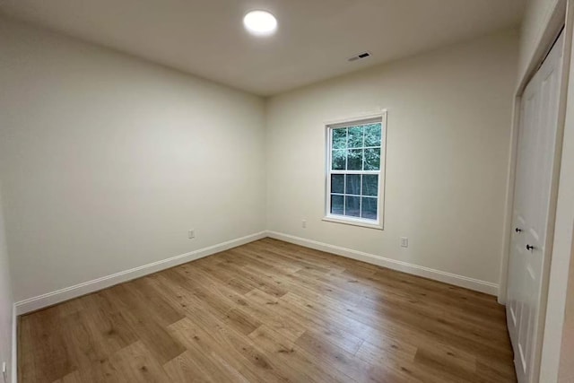 unfurnished bedroom featuring light wood-style floors, visible vents, and baseboards