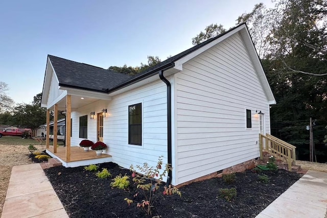 view of property exterior with crawl space and roof with shingles