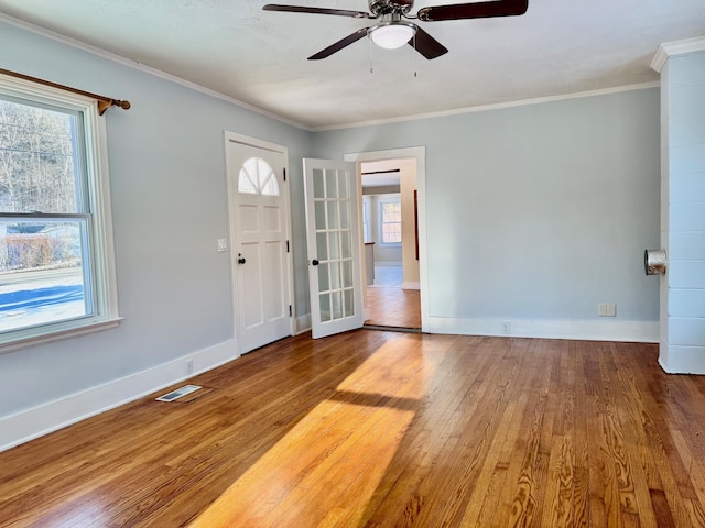 foyer entrance with hardwood / wood-style flooring, ornamental molding, and ceiling fan