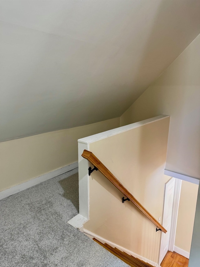 stairs featuring vaulted ceiling and carpet flooring