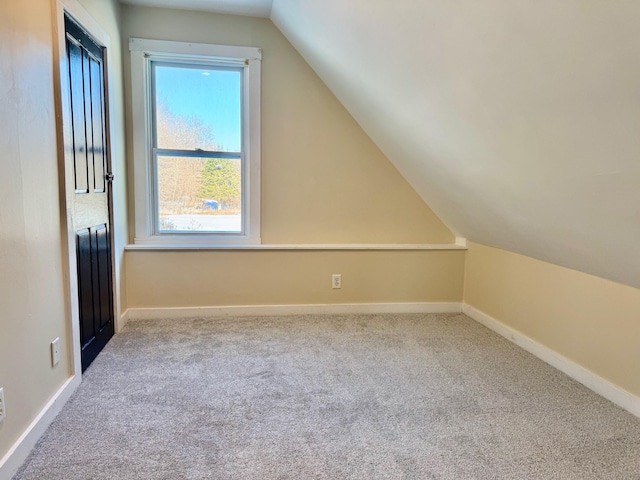 additional living space with light colored carpet and lofted ceiling