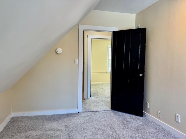 bonus room featuring light colored carpet and vaulted ceiling