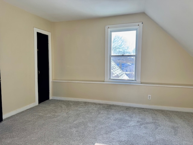 bonus room featuring vaulted ceiling and light carpet