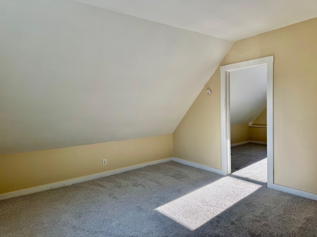 bonus room with light colored carpet and lofted ceiling