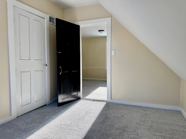 additional living space with lofted ceiling and light carpet