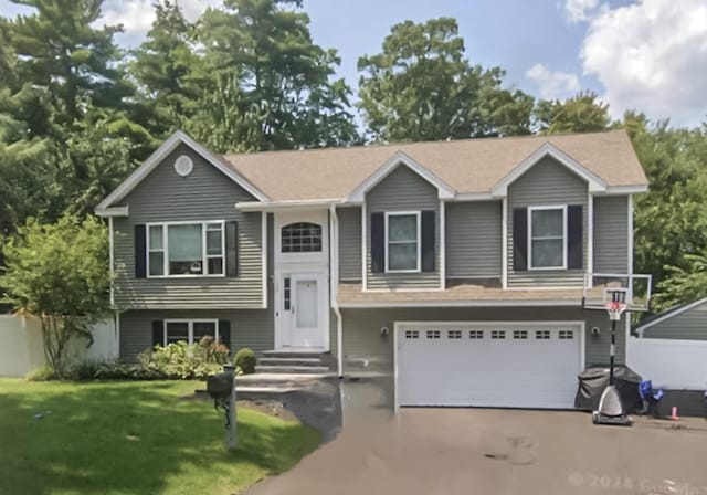 split foyer home featuring a garage and a front yard